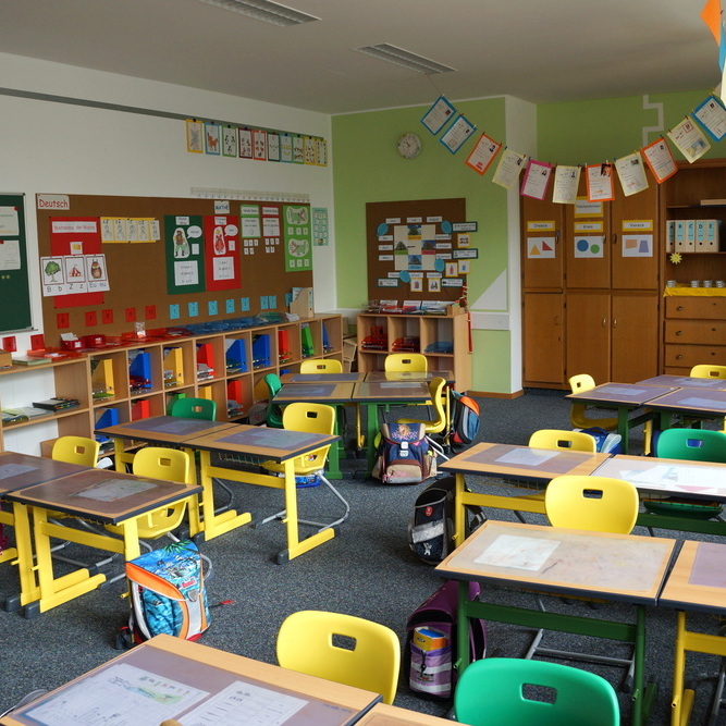 Blick in einen Klassenraum mit Schülertischen und Stühlen